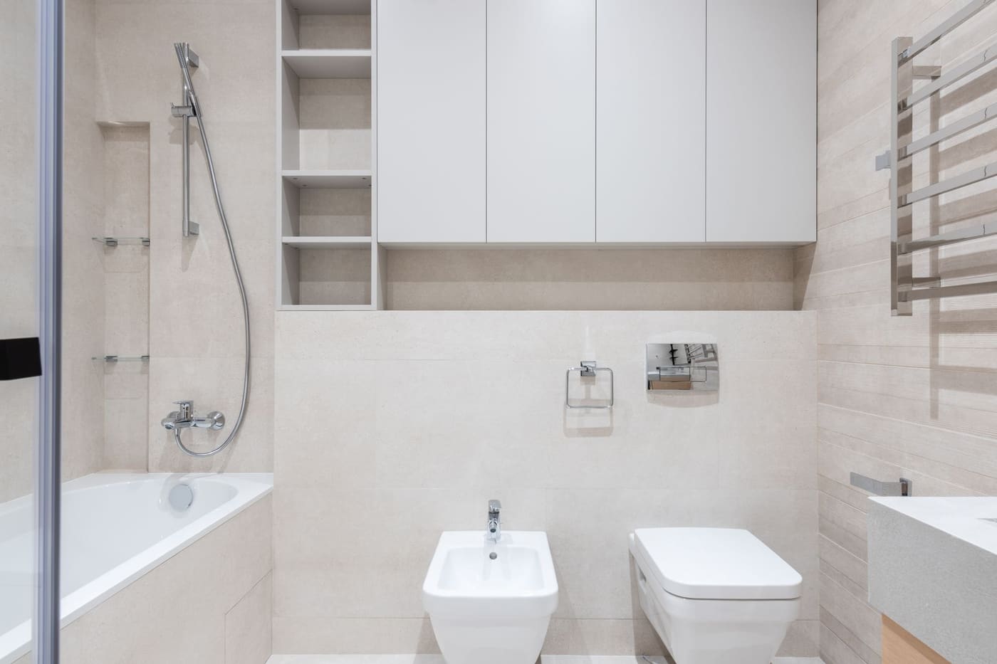 Wall cabinet mounted above a wall-hung toilet in a light bathroom