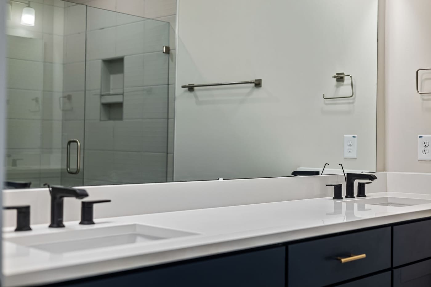 Vanity with matte black faucets and a matching black towel bar