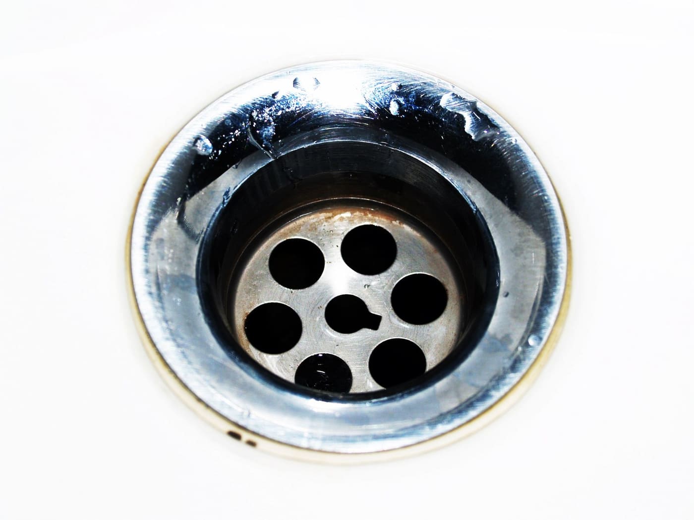Chrome sink drain with water drops around it