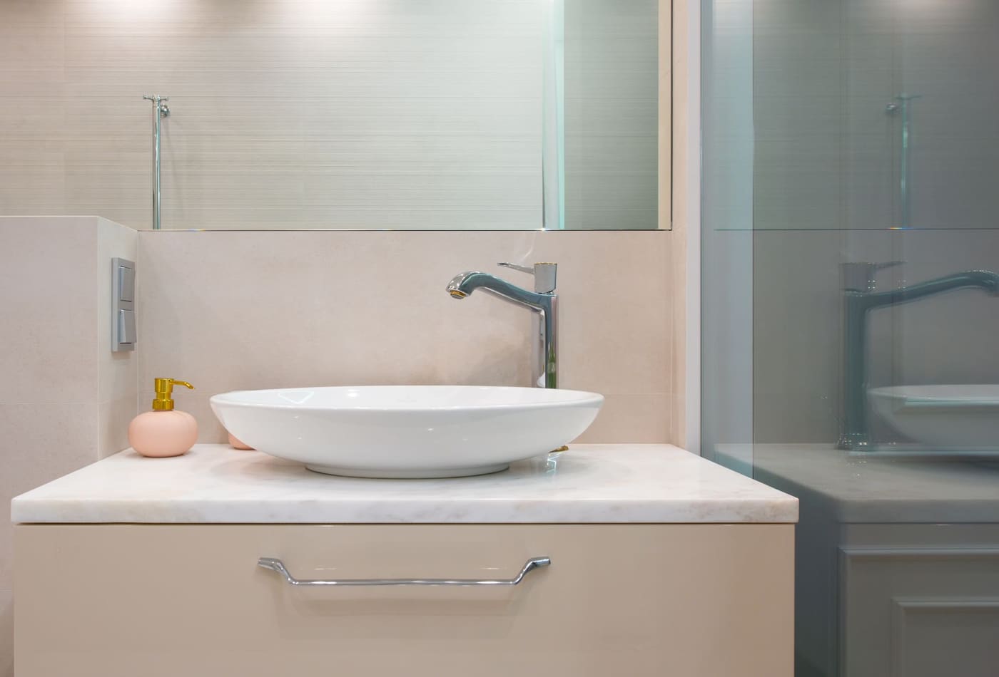 Light washroom with a sink and faucet on a clear counter
