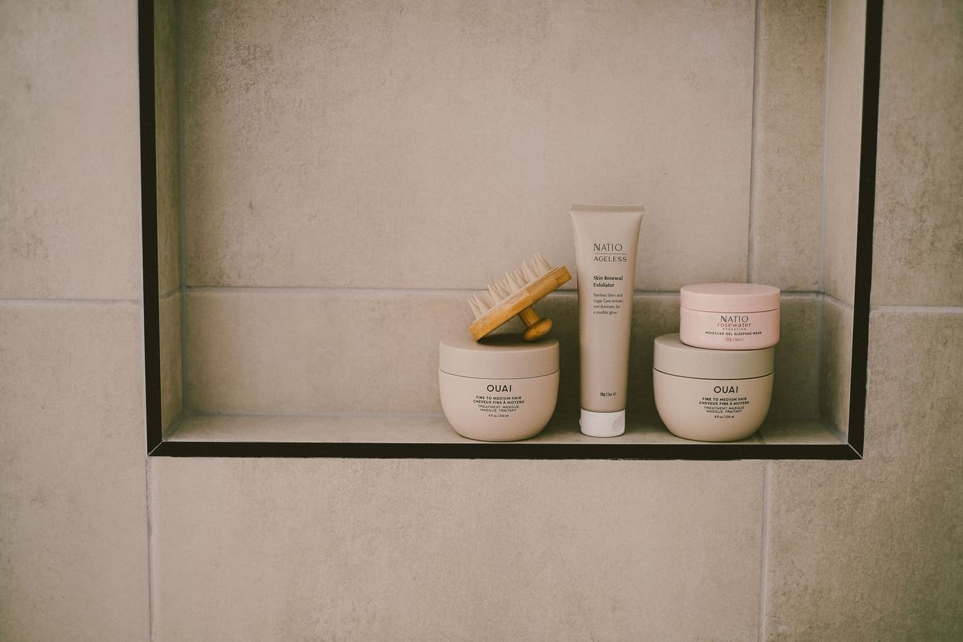 Recessed tile shower niche holding a few skincare products