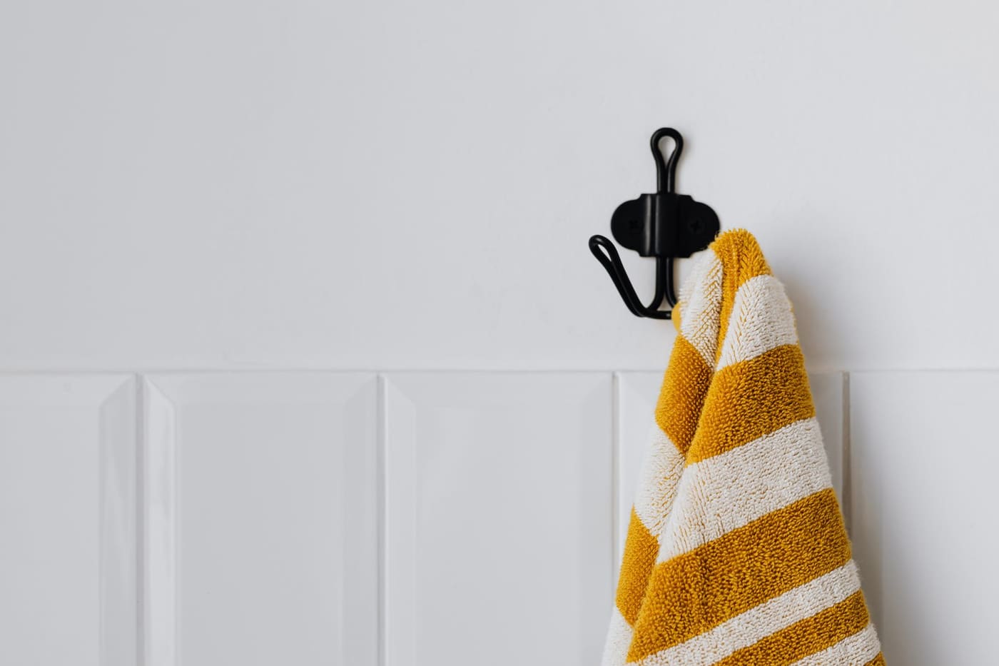 Yellow and white striped towel hanging from a black wall hook