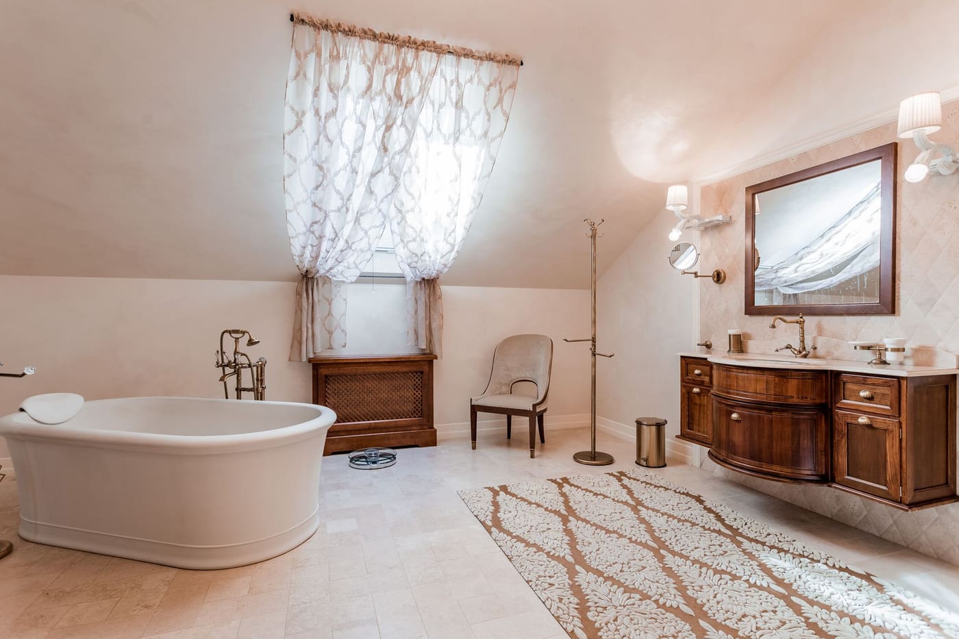 Bathroom with warm cream walls, a wood vanity and shaded wall lamps beside the mirror
