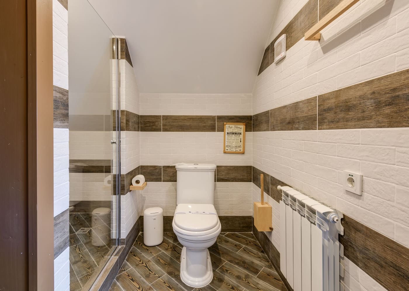 Small white bin in a bathroom with clean white tiles
