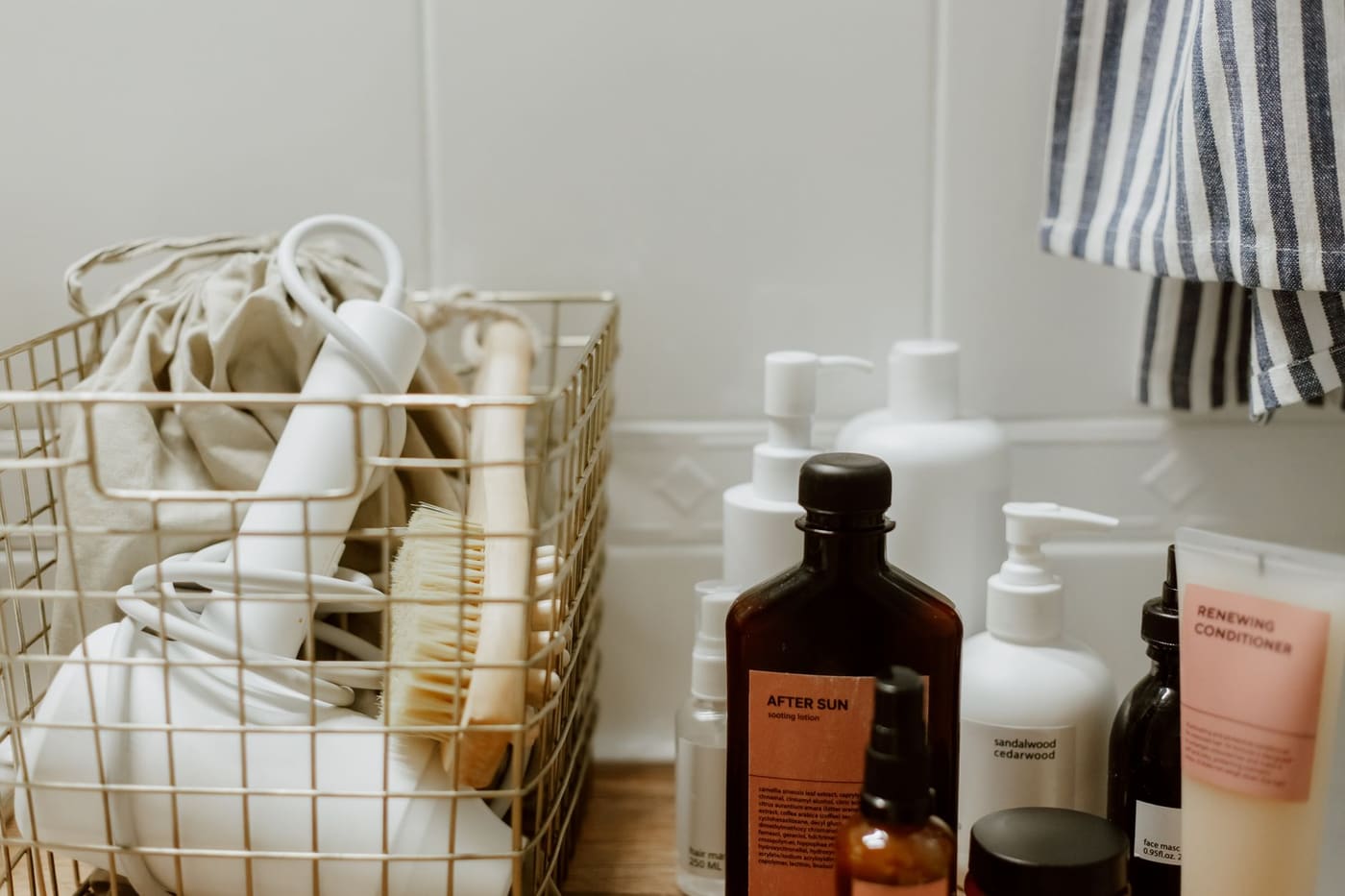 Wire basket holding bathroom products on a wooden shelf